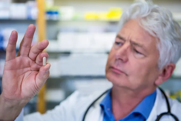 Pharmacist checking a capsule — Stock Photo, Image