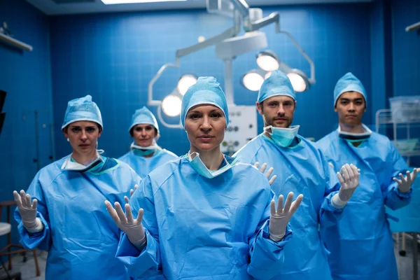 Cirujanos de pie con las manos levantadas — Foto de Stock