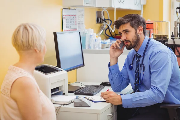 Doktor na recepci mluví o telefonu — Stock fotografie