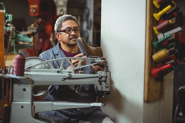 Zapatero examinando un zapato — Foto de Stock