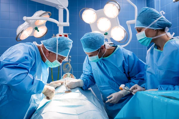 Chirurgiens effectuant une opération en salle d'opération — Photo