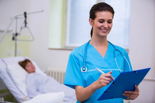 Enfermeira a verificar um relatório médico — Fotografia de Stock