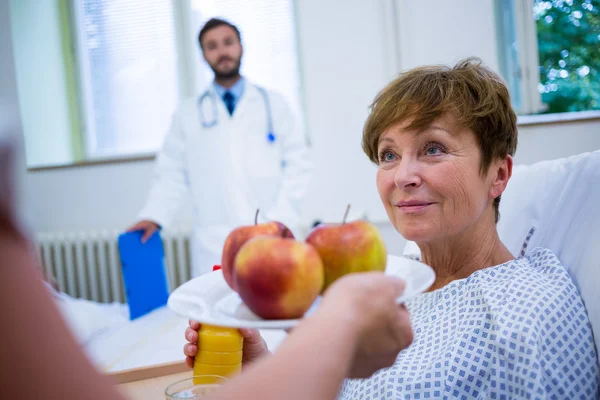 Медсестра, що подає сніданок пацієнту — стокове фото