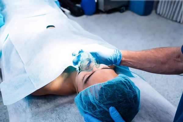 Chirurg setzt Sauerstoffmaske auf Gesicht des Patienten — Stockfoto