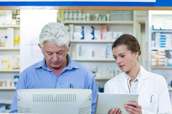 Pharmaciens utilisant une tablette numérique et un ordinateur — Photo