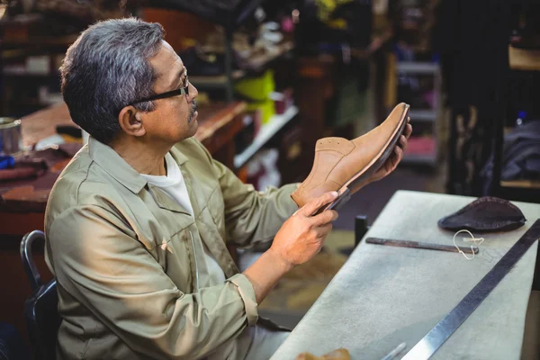 Τσαγκάρης εξετάζει ένα παπούτσι — Φωτογραφία Αρχείου
