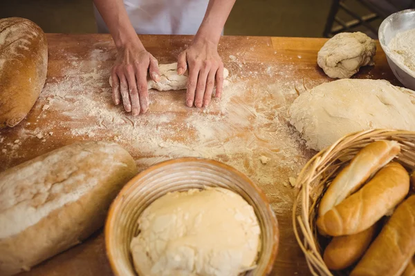 Hände einer Bäckerin beim Kneten eines Teiges — Stockfoto