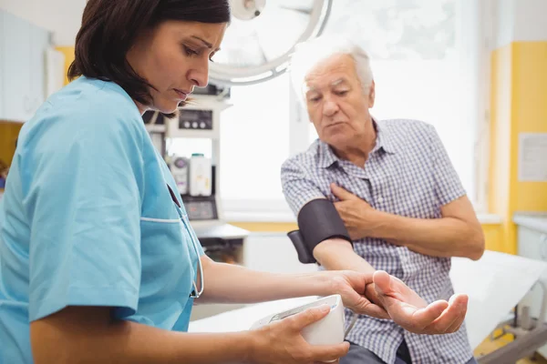 Doctor checking blood pressure of patient — Stock Photo, Image