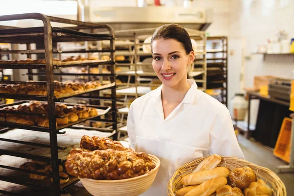 Vrouwelijke baker mand van zoete voedingsmiddelen te houden — Stockfoto