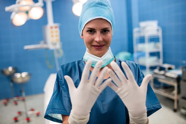 Ženský lékař zobrazeno chirurgické rukavice — Stock fotografie