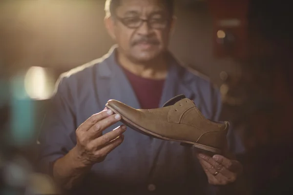Calzolaio esaminando una scarpa — Foto Stock
