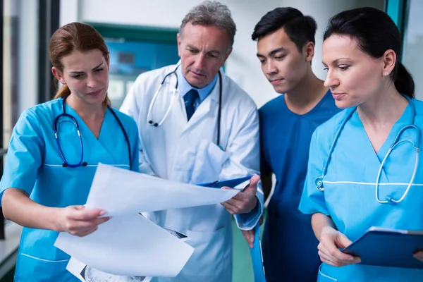 Médico y cirujanos discutiendo con el informe —  Fotos de Stock