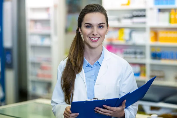 Farmacista che tiene cartella appunti in farmacia — Foto Stock