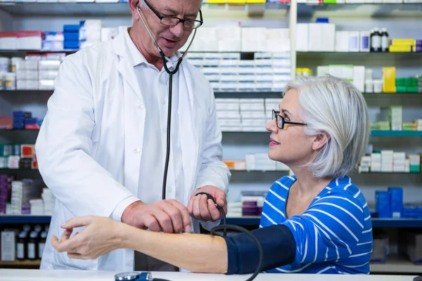 Apotheker die de bloeddruk van de klant controleert — Stockfoto