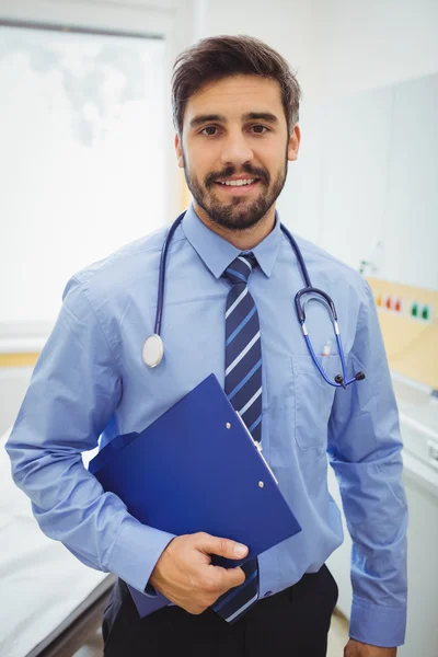 Smiling doctor holding clipboard — Stock Photo, Image