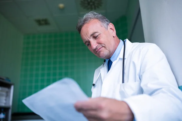 Médico que verifica o relatório médico — Fotografia de Stock