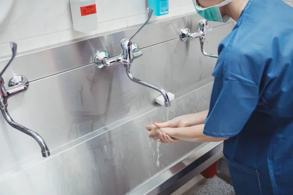 Vrouwelijke chirurg haar handen wassen — Stockfoto