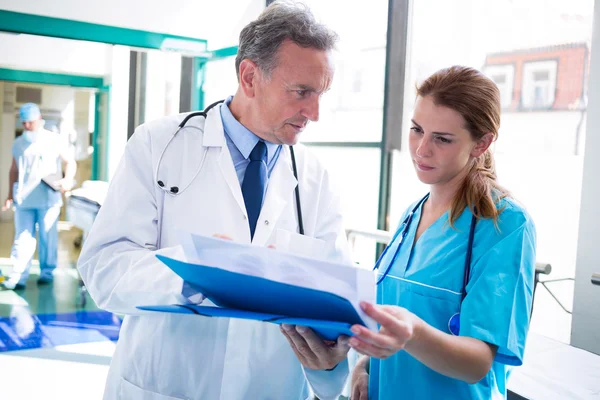 Médico e enfermeiro verificando o relatório médico — Fotografia de Stock