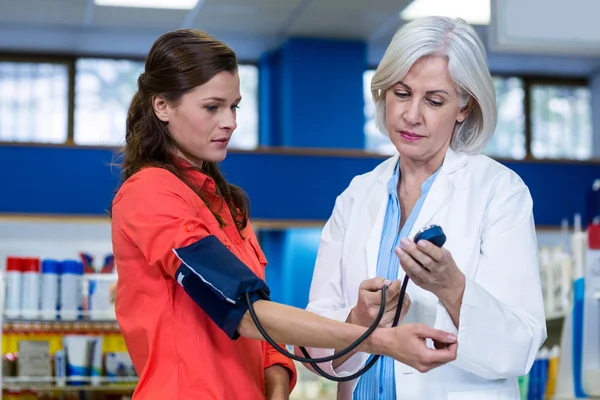 Pharmacist checking blood pressure of customer — Stock Photo, Image
