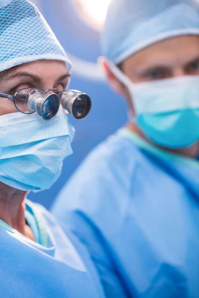 Cirurgião olhando através de lupas cirúrgicas — Fotografia de Stock