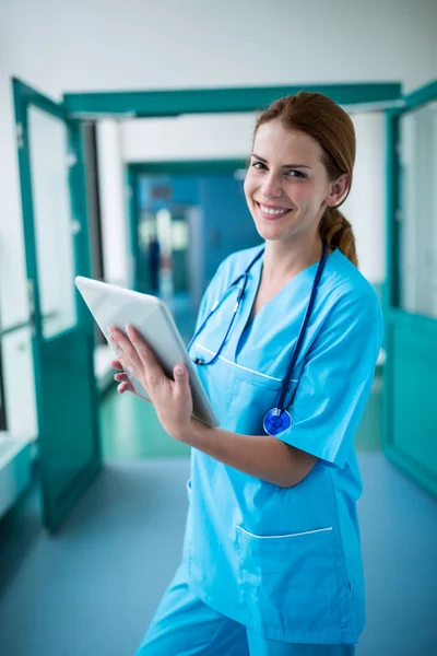 Хирург с помощью цифрового планшета в коридоре — стоковое фото