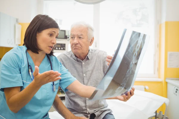 Doktor hastanın x-ray tartışıyor — Stockfoto
