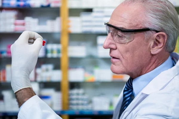 Pharmacist checking a capsule — Stock Photo, Image
