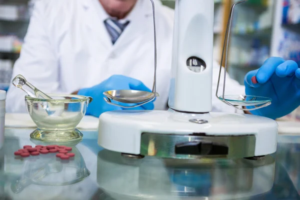 Pharmacist measuring tablets with pharmacy scale — Stock Photo, Image