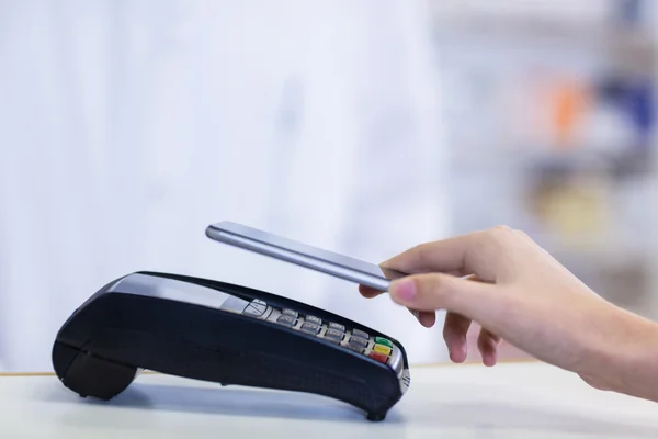 Frau bezahlt Rechnung per Smartphone — Stockfoto