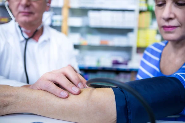 Pharmacist checking blood pressure of customer — Stock Photo, Image