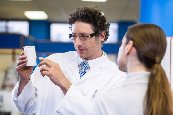 Farmacista che assiste la bottiglia di farmaco — Foto Stock