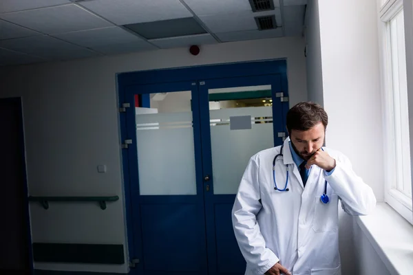 Грустный доктор, стоящий в коридоре — стоковое фото