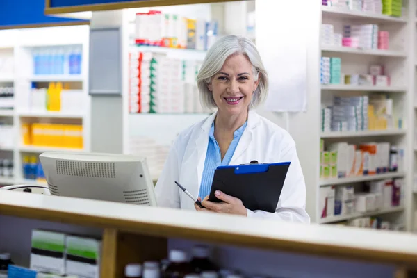 Farmacéutico sosteniendo un portapapeles en farmacia — Foto de Stock
