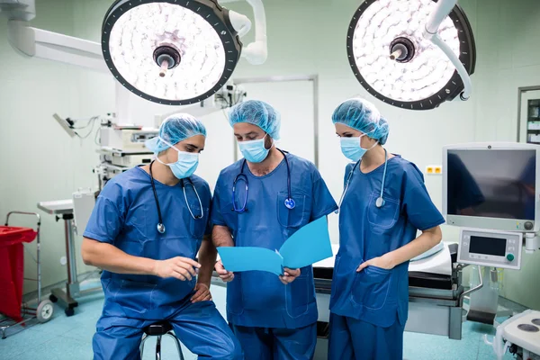 Хирурги обсуждают записи пациентов — стоковое фото
