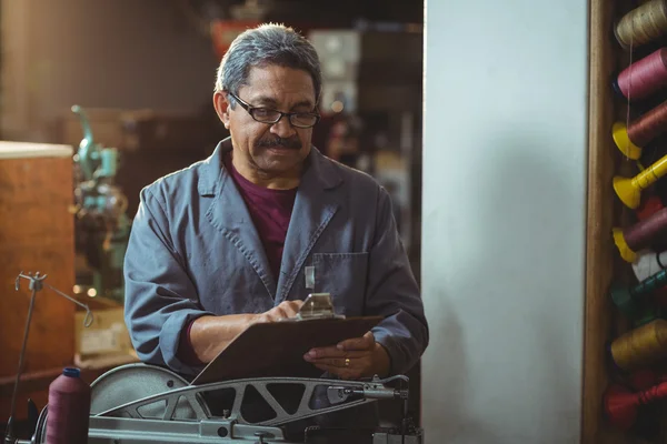 Shoemaker writing on clipboard — Stock Photo, Image