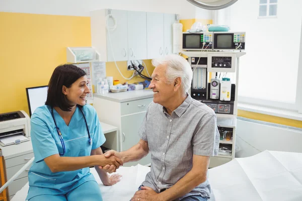 Dokter schudt handen met patiënt — Stockfoto