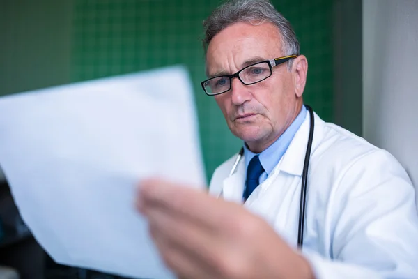 Médico examinando um relatório — Fotografia de Stock