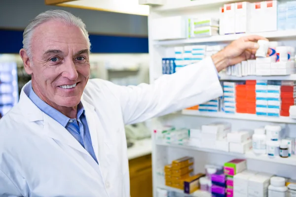 Pharmacist checking a bottle of drug — Stock Photo, Image