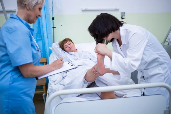 Doctor giving foot treatment to patient — Stock Photo, Image