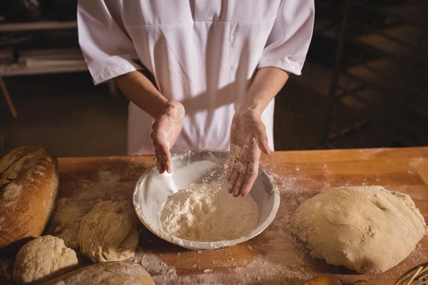 Női baker terjed a lisztet egy tálba — Stock Fotó