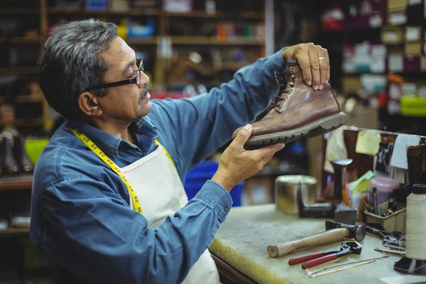 Shoemaker, zkoumání boty — Stock fotografie