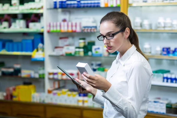 Pharmacist using tablet while checking medicine — Stock Photo, Image
