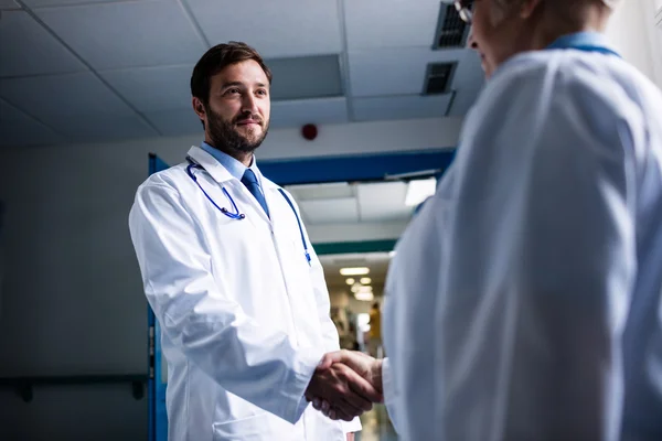 Médicos dándose la mano en el pasillo — Foto de Stock