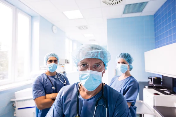 Cirurgião e enfermeiros de pé no hospital — Fotografia de Stock