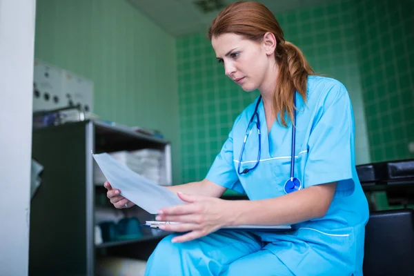 Sjuksköterska kontrollera medicinsk rapport — Stockfoto