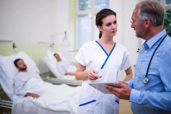 Dokter en verpleegster bespreken over digitale tablet — Stockfoto