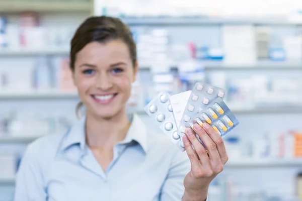 Farmacêutico mostrando medicina na farmácia — Fotografia de Stock