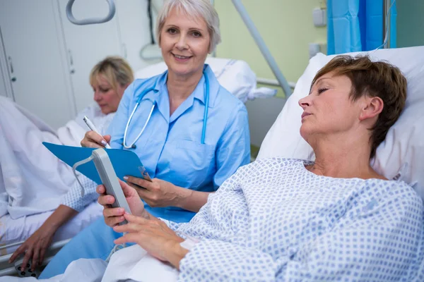 Paziente con dispositivo medico e infermiere seduto — Foto Stock