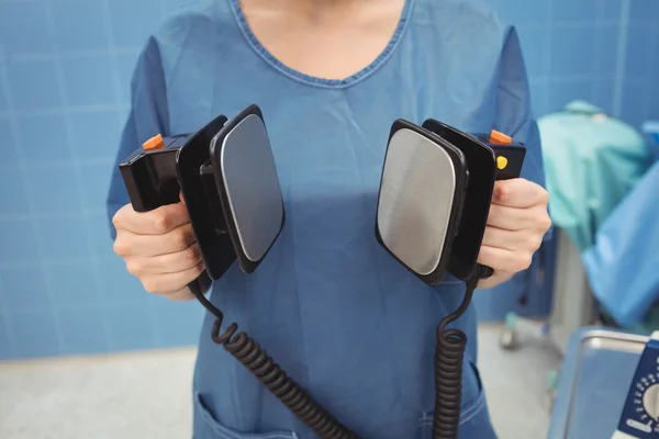 Female surgeon holding defibrillator — Stock Photo, Image