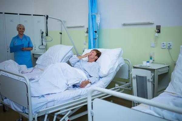 Senior patienten skrattar liggande på en säng — Stockfoto